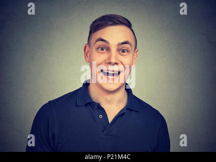 Überrascht Mann an der Kamera auf grauem Hintergrund suchen Stockfoto