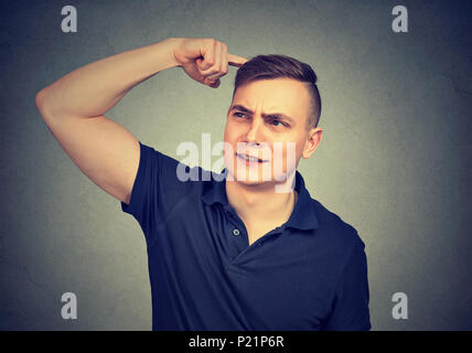 Closeup Portrait man kratzen Kopf, Gedanken über etwas, bis suchen, auf grauen Hintergrund. Stockfoto