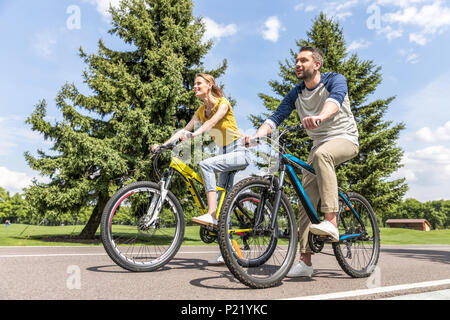 Junge casual Paar reiten auf Fahrräder im Park am Tag Stockfoto