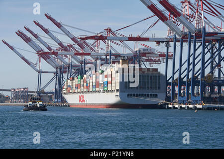 Containerschiff, OOCL LONDON, über den langen Strand Container Terminal, einem Traktor Schlepper nähert sich das Schiff zu verlassen. Hafen von Long Beach, USA. Stockfoto