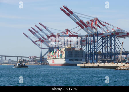 Container Ship, OOCL LONDON, fährt gleich vom Long Beach Container Terminal ab, Einem Traktor-Tug, Der sich dem Schiff nähert. Hafen Von Long Beach, Kalifornien Stockfoto