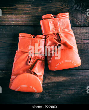 Paar rote Leder Handschuhe für den Boxsport auf braunem Holz- Hintergrund Stockfoto