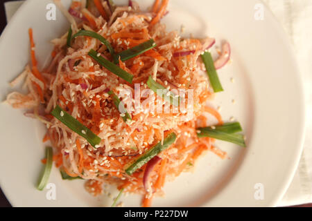 Vegan Salat mit Karotten und Rettich. Asiatische Küche. Gesunde vegetarische Vorspeise auf die runde Platte. Beilage. Einfach wenig Kalorien Mittagessen. Ansicht von oben. Stockfoto