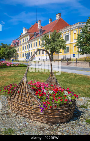 Anzeigen eines großen Stroh Korb mit Blumen in einem Park mit dem Museum in der Burg Eltz im Hintergrund in Vukovar, Kroatien. Stockfoto