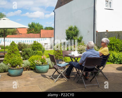Ein älteres Paar beim Tee am Nachmittag im Garten eines Café in Thirsk North Yorkshire England Stockfoto
