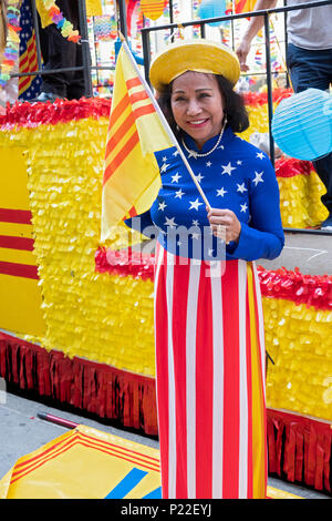 Ein Einwanderer tragen eines Stars und Streifen dress und winken einem Südvietnamesischen Flagge bei der Vietnamesischen Amerikanischen kulturellen Parade. Stockfoto