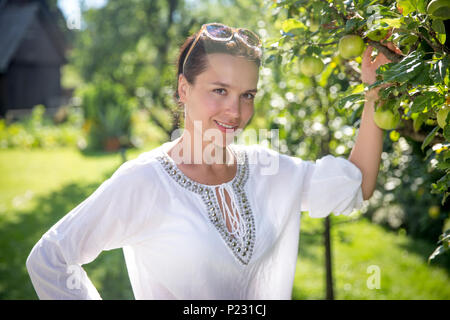 Schöne junge Frau in einem Obstgarten auf Land Stockfoto