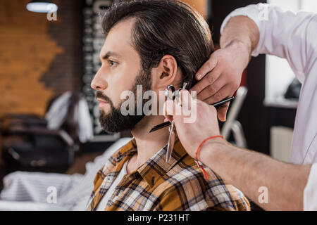 Seitenansicht des bärtigen Mann erste Haarschnitt im barbershop Stockfoto