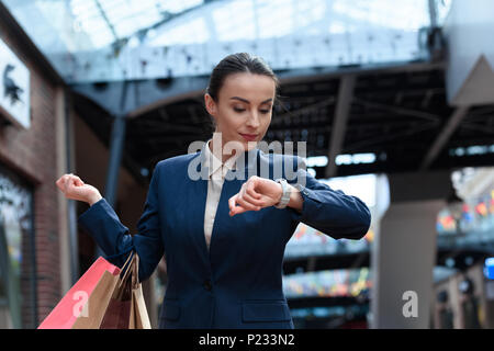 Attraktive Geschäftsfrau Kontrolle Zeit im Einkaufszentrum Stockfoto