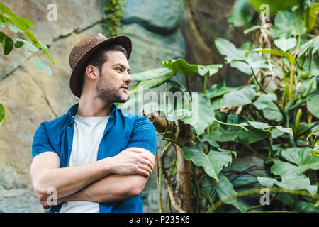 Junger Mann in Strohhut und stilvolle Kleidung im Regenwald Stockfoto