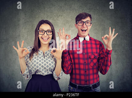 Erfolg und Sieg Konzept. Junge lustig Paar showig ok Zeichen zum Ausdruck bringen Spannung, Staunen und Freude Stockfoto