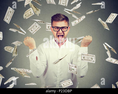 Junge eleganter und intelligenter Mann siegreich in † flying Dollarscheine posieren. Stockfoto