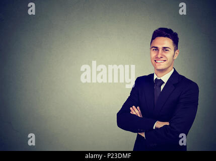 Portrait von zuversichtlich heiter Geschäftsmann auf grauem Hintergrund Stockfoto