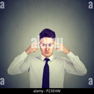Business Mann intensiv Denken auf grauen Hintergrund konzentrieren. Stockfoto