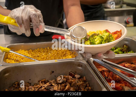 Ein Arbeiter bereitet einen Salat zum Mittagessen in einem Fast Food Restaurant in Midtown Manhattan in New York am Donnerstag, 7. Juni 2018. (© Richard B. Levine) Stockfoto