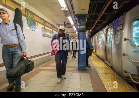 Wochenende der u-bahn Fahrer warten auf einen Zug an der 8th Street Station in der New Yorker U-Bahn am Donnerstag, 7. Juni 2018. (Â© Richard B. Levine) Stockfoto