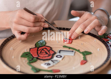 Arbeitsplatz eines Mosaik Master: weibliche Hände, mit einem Mosaik Element auf dem Tisch Stockfoto