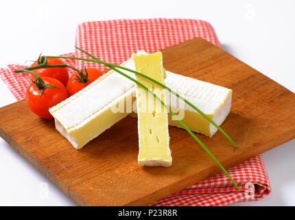 Scheiben Frischkäse mit weißen Rinde auf Holz Schneidebrett - Nahaufnahme Stockfoto