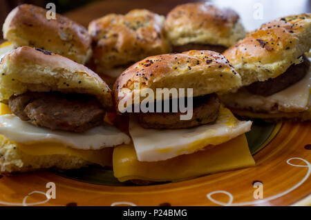 Wurst Ei und Käse Frühstück sanwich platter auf Zwiebel Mohn- Brötchen Stockfoto