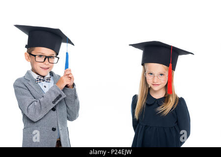 Adorable Schüler an der Staffelung Hüte isoliert auf weißem Stockfoto