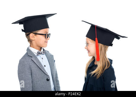 Adorable Schüler an der Staffelung Hüte an einander Suchen isoliert auf weißem Stockfoto