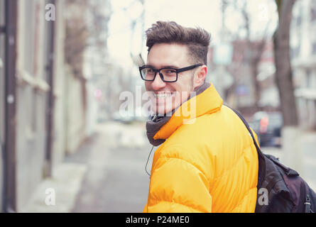Junge stilvollen Mann in Oberbekleidung und Brillen über die Schulter schauen auf die Straße. Stockfoto