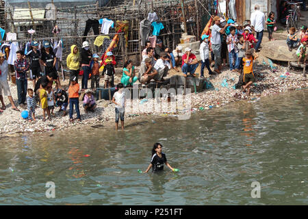 Phan Thiet, Vietnam - Januar 2014: Viele Menschen am Ufer und im Wasser in Richtung der traditionellen Drachenbootrennen suchen im neuen Jahr in der Pha Stockfoto