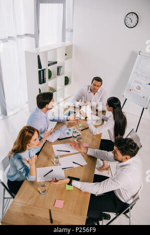 Hohe Betrachtungswinkel von Kollegen diskutieren Geschäftsidee am Arbeitsplatz im Büro Stockfoto