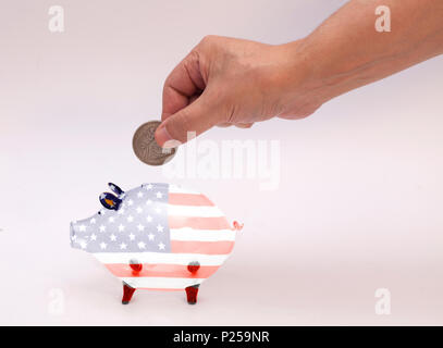 Mann, Münze in Sparschwein mit USA-Flagge auf weißem Hintergrund Stockfoto