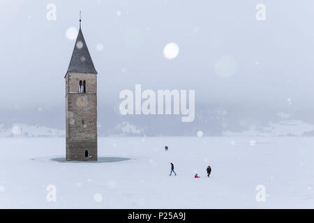 Die versunkenen Kirchturm von Graun im Vinschgau, Provinz Bozen, Südtirol, Italien, unter einem Schneefall Stockfoto