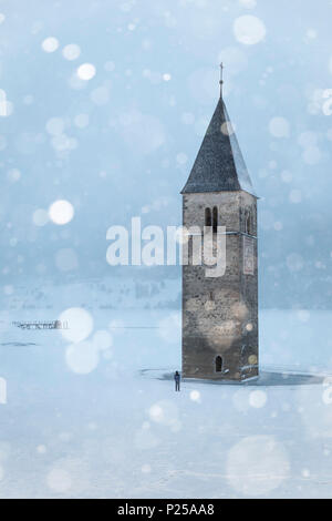 Die versunkenen Kirchturm von Graun im Vinschgau, Provinz Bozen, Südtirol, Italien, unter einem Schneefall Stockfoto