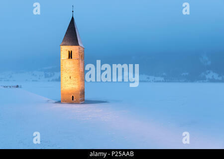 Die versunkenen Kirchturm von Graun im Vinschgau, Provinz Bozen, Südtirol, Italien, unter einem Schneefall Stockfoto