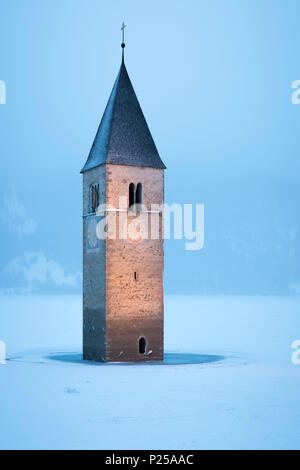 Die versunkenen Kirchturm von Graun im Vinschgau, Provinz Bozen, Südtirol, Italien, unter einem Schneefall Stockfoto