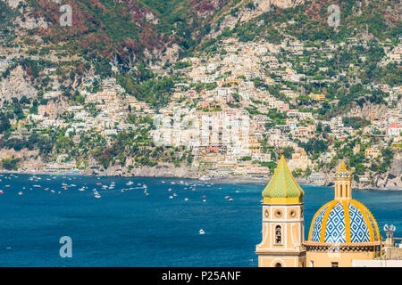 Praiano, Amalfi, Salerno, Kampanien, Italien. Die Kirche von Praiano mit Positano Dorf im Hintergrund Stockfoto