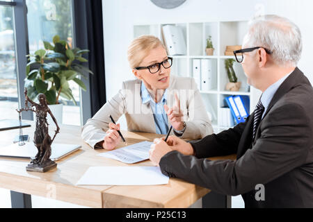 Ausgereifte Kollegen diskutieren Vertrag in modernen Büro Stockfoto