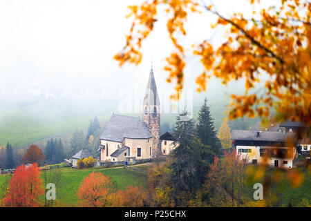 Kirche von Santa Magdalena im Herbst Nebel. Funes Tal, Südtirol, Dolomiten, Italien Stockfoto