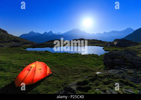 Nacht der Vollmond mit Camping am Ufer eines kleinen Sees. Alpe Foren, Valmalenco, Valtellina, Lombardei, Italien. Stockfoto