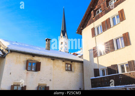 Glockenturm der Kirche von Zuoz mit Sun in einem Fenster nieder. Zuoz, Engadin, Graubünden, Schweiz. Stockfoto