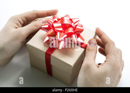 Des Menschen Hände geben Sie eine Geschenkverpackung closeup Stockfoto