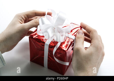 Des Menschen Hände geben Sie eine Geschenkverpackung closeup Stockfoto