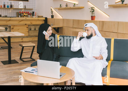 Junge muslimische Geschäftsleute in Gespräch im Cafe Stockfoto