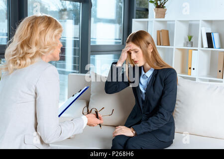 Reifen Psychologen sprechen mit gedrückter junge Frau während der Therapie Stockfoto