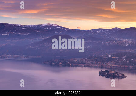 Winter Sonnenaufgang auf der Insel San Giulio am Lago d'Orta aus der Madonna del Sasso Wallfahrtskirche in Boleto, Orta See, Provinz Novara, Piemont, Italien Stockfoto