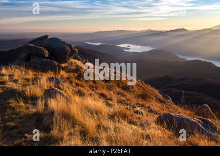 Blick auf den Monte Rosa und Lago d'Orta, die aus einer Gruppe von Felsen an der Oberseite des Mottarone bei Sonnenuntergang. Stresa, Verbano Cusio Ossola, Piemont, Italien. Stockfoto