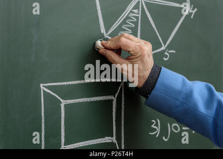 Zugeschnittenes Bild von Professor Zeichnung mit Stück Kreide an der Tafel Stockfoto