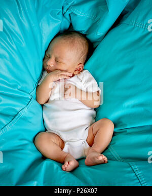 Baby Boy schlafen in einem Teal Blue Sitzsack Stockfoto