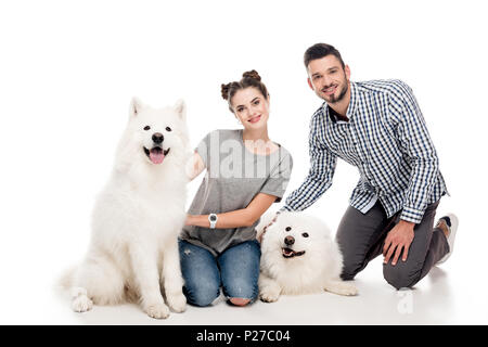 Glückliches Paar sitzen mit Hunden auf Weiß Stockfoto