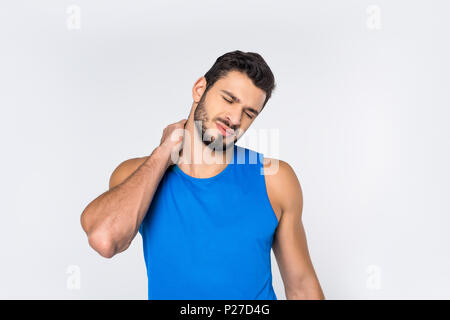 Sportler mit geschlossenen Augen in Rückenschmerzen isoliert auf weißem Stockfoto