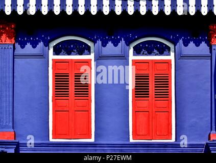 Vorderansicht des bunten Erbe Singapur shop Haus mit blauen Fassade, antiken rot Lamellenfensterläden und Bogenfenstern in historischen Little India Stockfoto