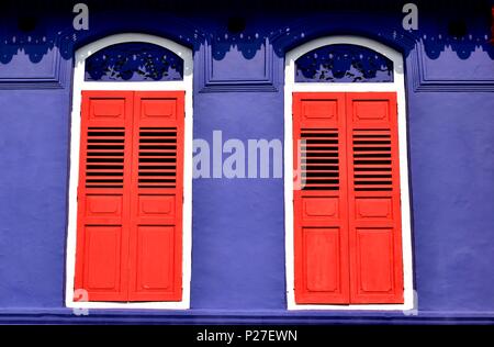 Vorderansicht des bunten Erbe Singapur shop Haus mit blauen Fassade, antiken rot Lamellenfensterläden und Bogenfenstern in historischen Little India Stockfoto